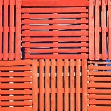 Orange shipping pallets stacked as a fence